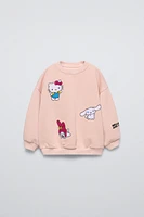 Round neck sweatshirt with long sleeves. Rib trim. HELLO KITTY and FRIENDS © front embroidery detail. Warm soft interior.