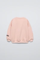 Round neck sweatshirt with long sleeves. Rib trim. HELLO KITTY and FRIENDS © front embroidery detail. Warm soft interior.