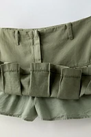 Skirt with interior adjustable waistband and side zip closure. Box pleats at hem.