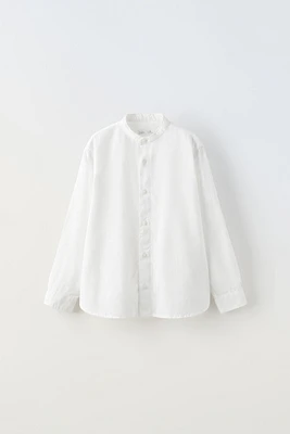 Long sleeve banded collar shirt. Front button closure. Fabric is 77% cotton and 23% linen.