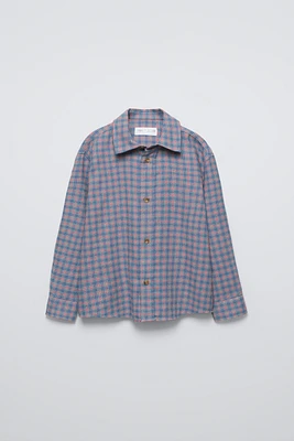 shirt with collar, long sleeves, and elastic cuffs. Front button closure. Check print.