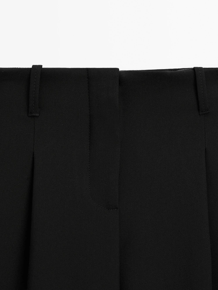 Flowing mid-waist trousers with buckles