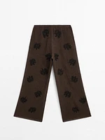 Flowing textured trousers with embroidered detail