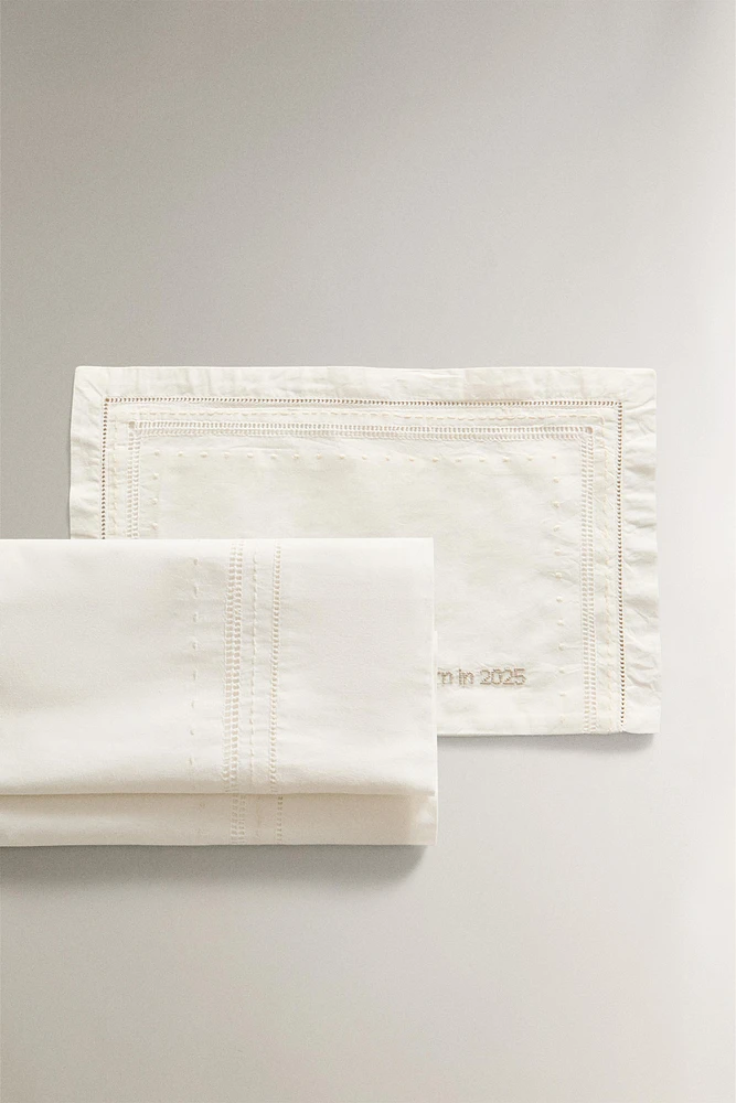 ‘BORN IN 2025’ EMBROIDERED MINI CRIB SHEET SET