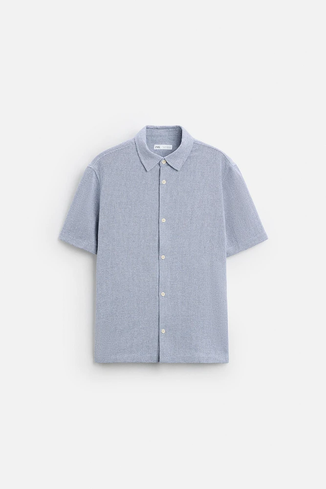 Relaxed fit shirt made of cotton blend fabric. Lapel collar and short sleeves. Side vents at hem. Front button closure.