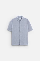 Relaxed fit shirt made of cotton blend fabric. Lapel collar and short sleeves. Side vents at hem. Front button closure.