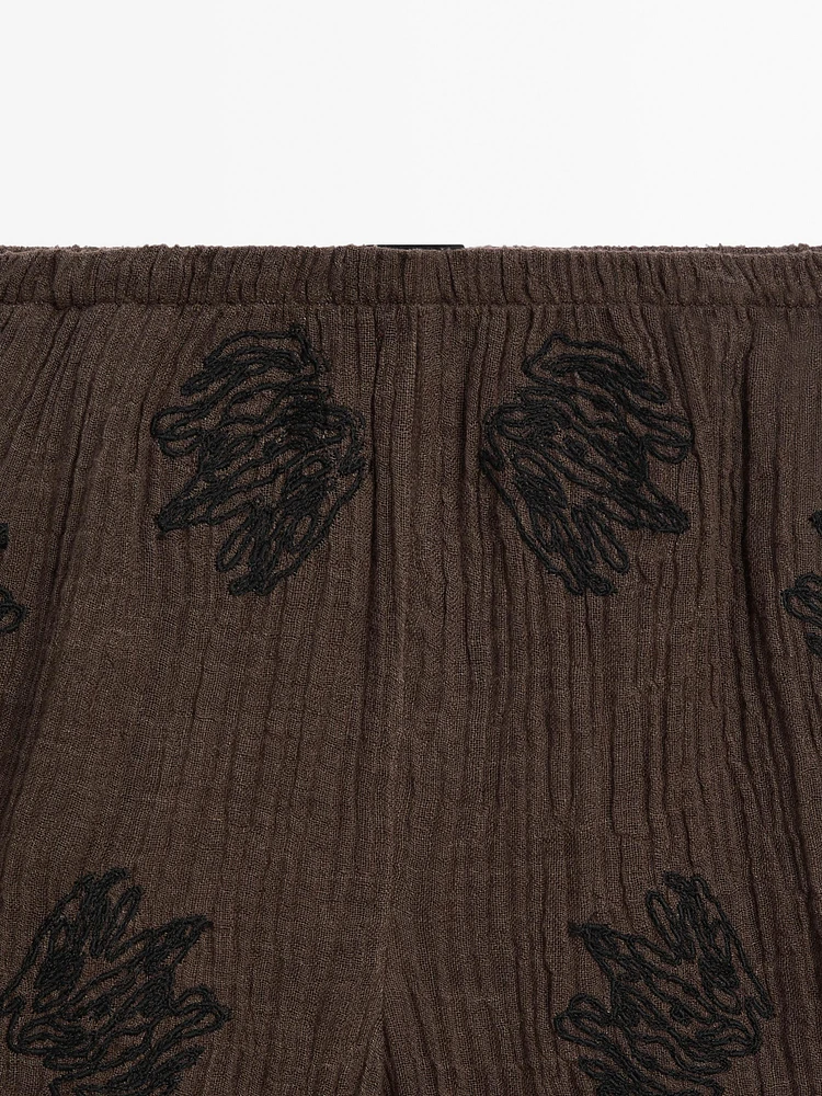 Flowing textured trousers with embroidered detail