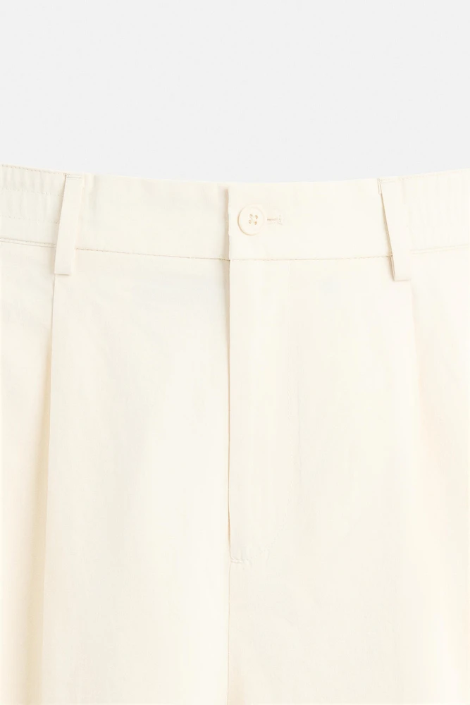 PLEATED CHINO PANTS