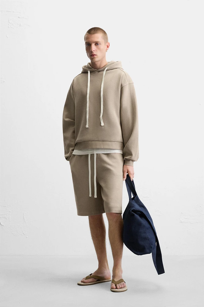 SWEAT À CAPUCHE ET INSCRIPTION