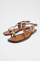 FLAT SANDALS WITH STRAPS AND METAL DETAIL