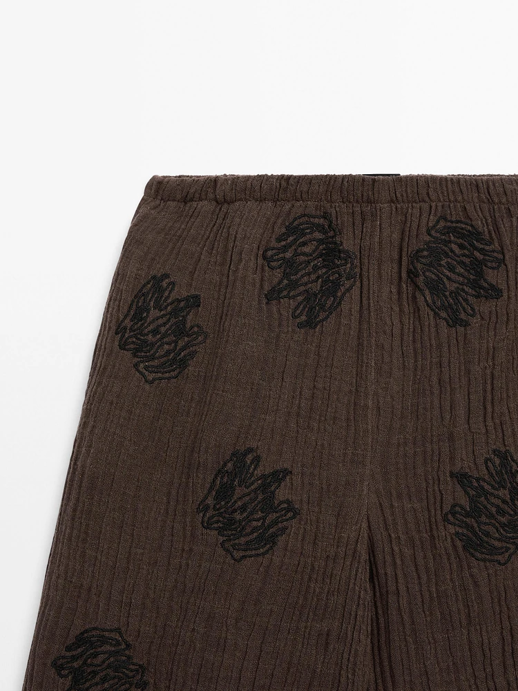 Flowing textured trousers with embroidered detail