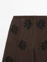 Flowing textured trousers with embroidered detail
