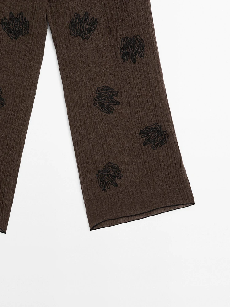 Flowing textured trousers with embroidered detail