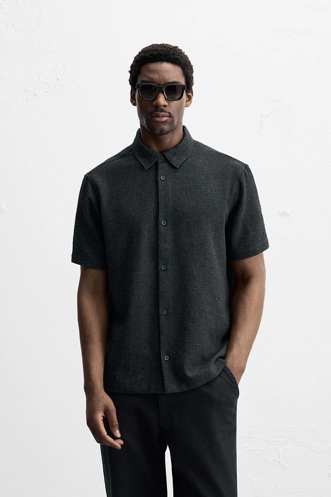 Relaxed fit shirt made of cotton blend fabric. Lapel collar and short sleeves. Side vents at hem. Front button closure.