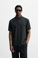 Relaxed fit shirt made of cotton blend fabric. Lapel collar and short sleeves. Side vents at hem. Front button closure.