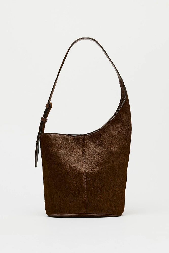 ASYMMETRIC FUR-TRIMMED LEATHER BUCKET BAG