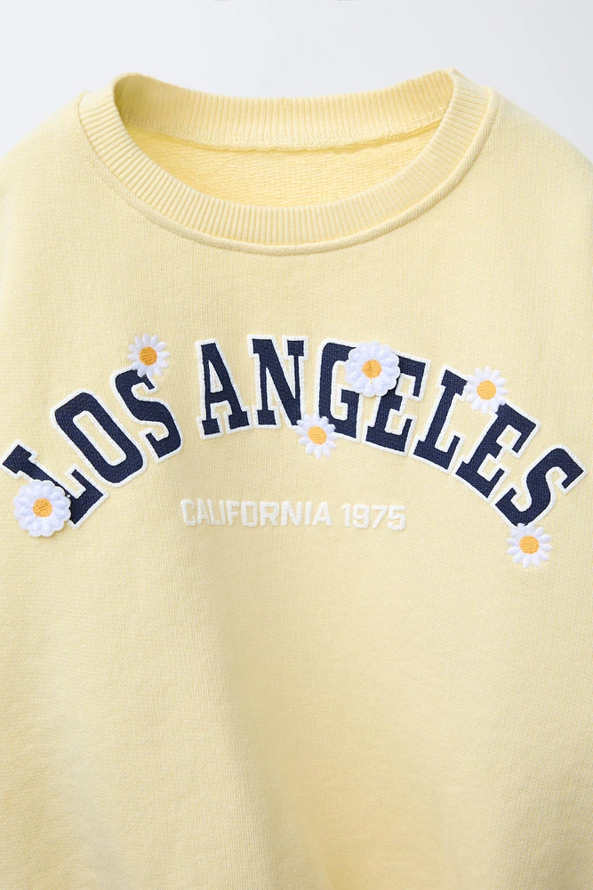 RAISED TEXT DAISY SWEATSHIRT