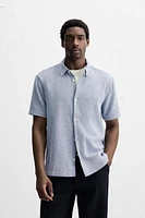Relaxed fit shirt made of cotton blend fabric. Lapel collar and short sleeves. Side vents at hem. Front button closure.