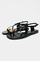 FLAT STRAPPY SANDALS WITH METAL ORNAMENT