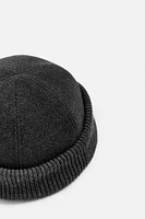 Hat made of tonal matching fabrics with turned-up knit brim. Adjusts loop.