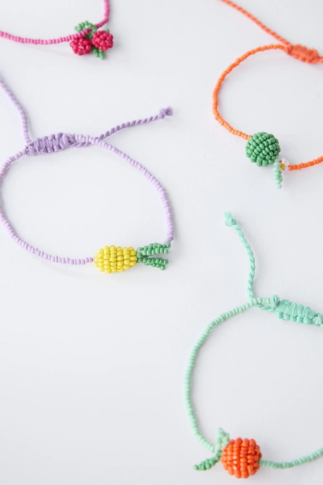 LOT DE QUATRE BRACELETS FANTAISIE ET FRUITS