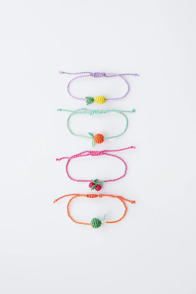 LOT DE QUATRE BRACELETS FANTAISIE ET FRUITS