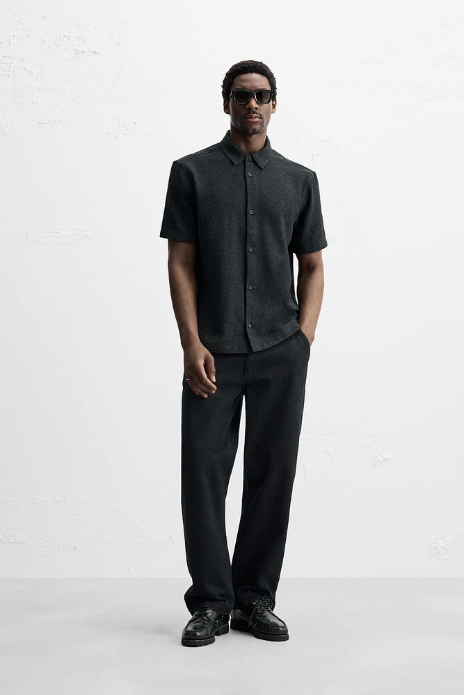 Relaxed fit shirt made of cotton blend fabric. Lapel collar and short sleeves. Side vents at hem. Front button closure.