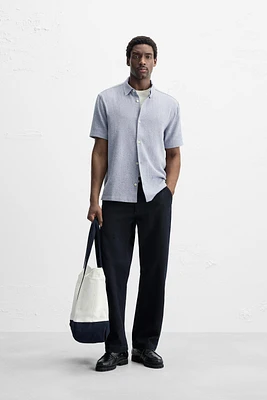Relaxed fit shirt made of cotton blend fabric. Lapel collar and short sleeves. Side vents at hem. Front button closure.