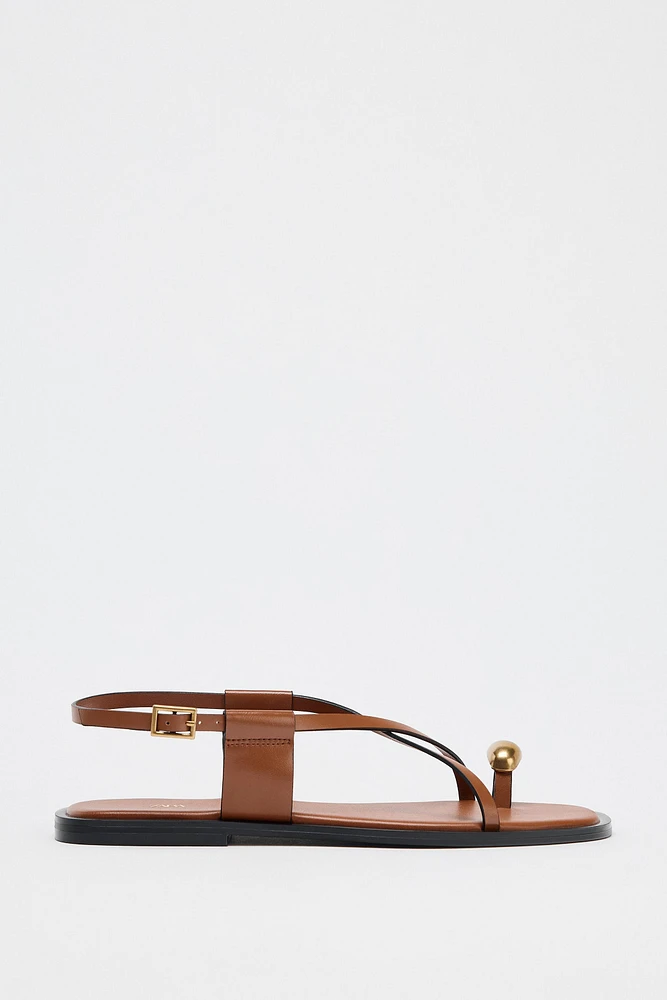 FLAT SANDALS WITH STRAPS AND METAL DETAIL