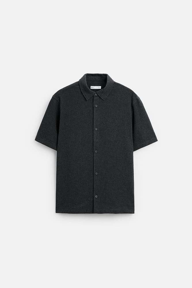 Relaxed fit shirt made of cotton blend fabric. Lapel collar and short sleeves. Side vents at hem. Front button closure.