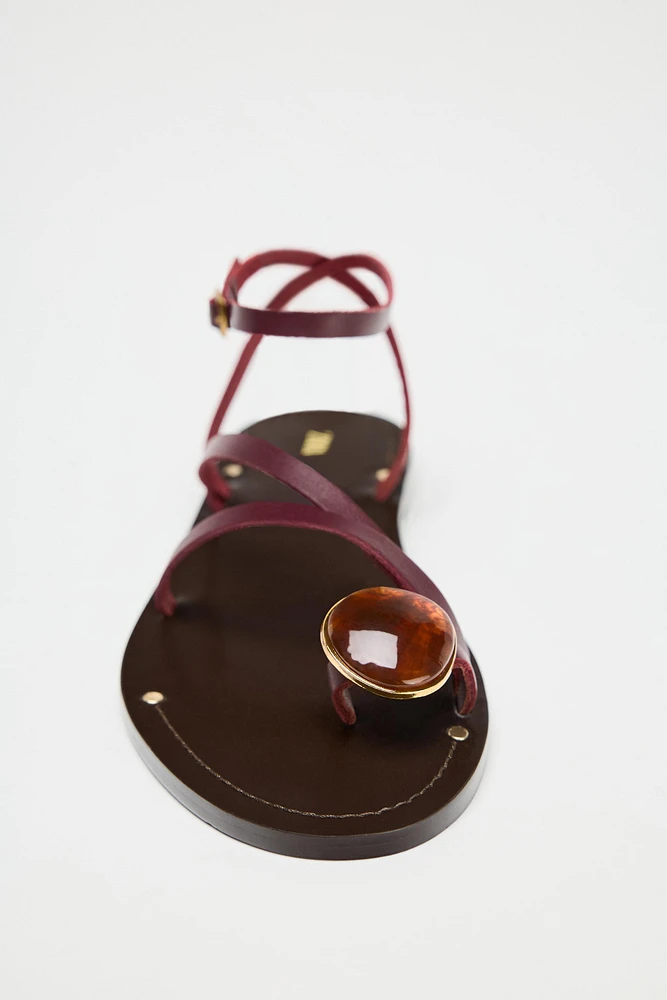 SANDALES PLATES EN CUIR AVEC BRIDES ET DÉCORATION