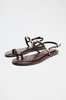 FLAT SANDALS WITH METAL APPLIQUÉ