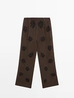 Flowing textured trousers with embroidered detail