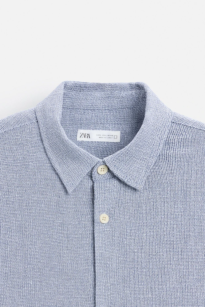 Relaxed fit shirt made of cotton blend fabric. Lapel collar and short sleeves. Side vents at hem. Front button closure.