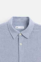 Relaxed fit shirt made of cotton blend fabric. Lapel collar and short sleeves. Side vents at hem. Front button closure.