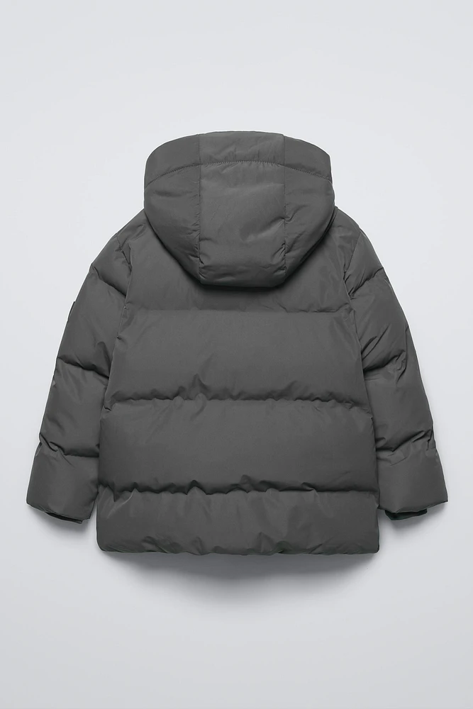 MANTEAU DÉPERLANT ÉTIQUETTE