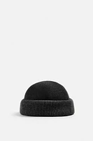 Hat made of tonal matching fabrics with turned-up knit brim. Adjusts loop.