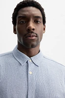 Relaxed fit shirt made of cotton blend fabric. Lapel collar and short sleeves. Side vents at hem. Front button closure.
