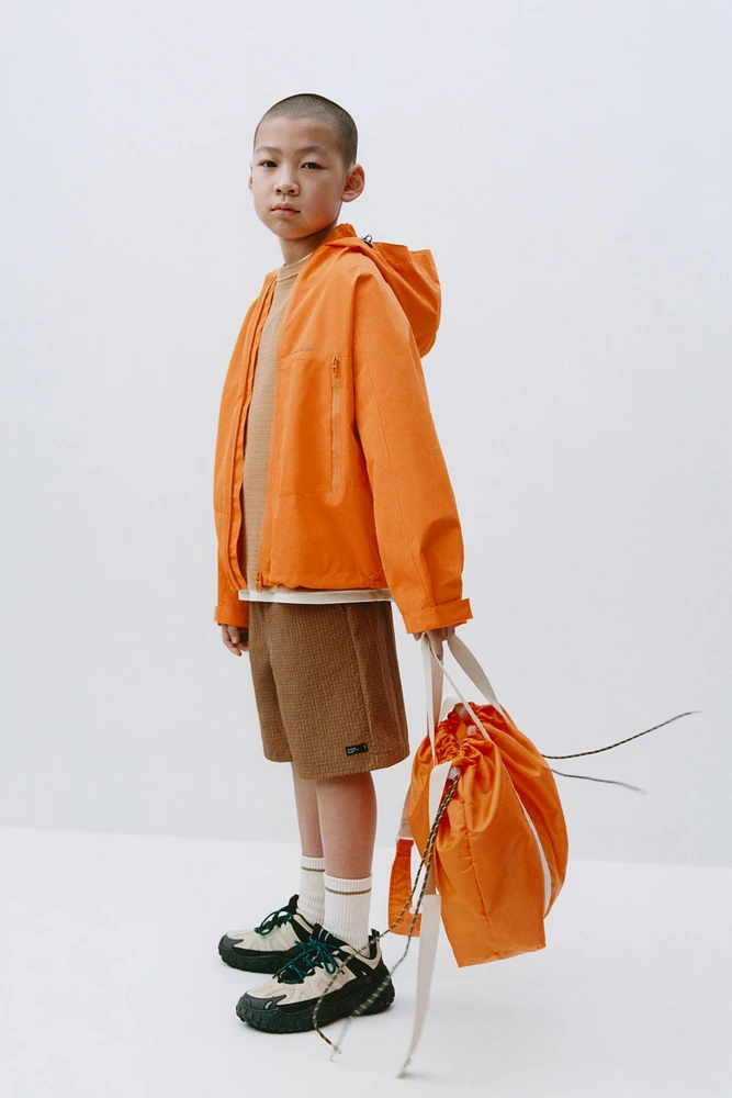 VESTE LÉGÈRE À CAPUCHE DÉPERLANTE