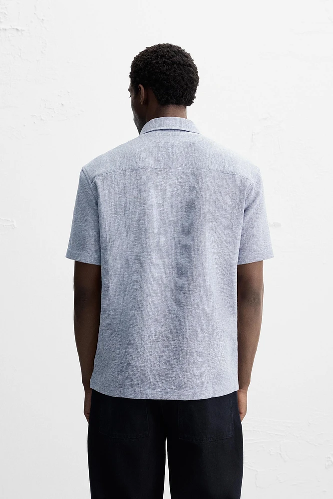Relaxed fit shirt made of cotton blend fabric. Lapel collar and short sleeves. Side vents at hem. Front button closure.