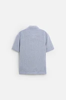 Relaxed fit shirt made of cotton blend fabric. Lapel collar and short sleeves. Side vents at hem. Front button closure.