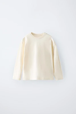 T-shirt with round neck and long sleeves. Label appliqué at back hem.