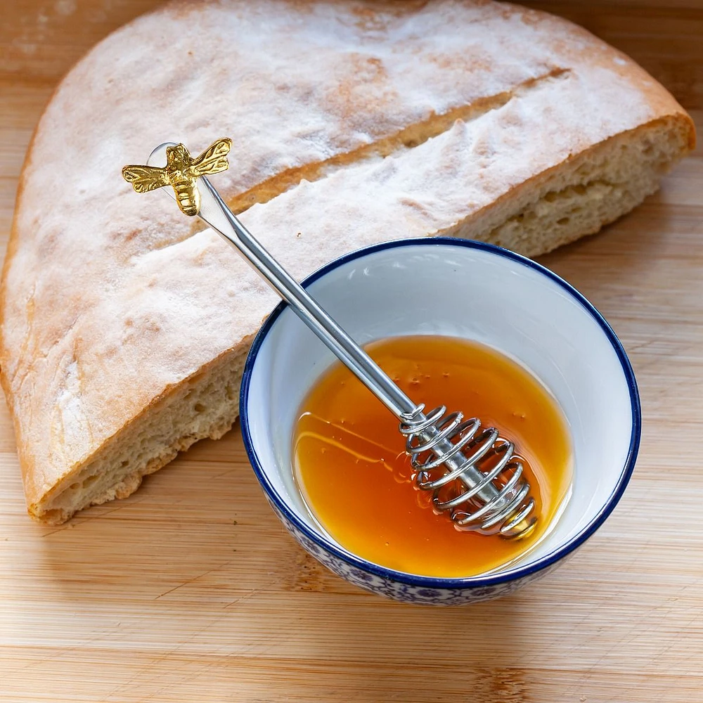 Cuillère à miel avec abeille sur le manche