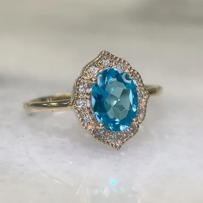 Ring with 8X6MM Oval Blue Topaz and .08 Carat TW of Diamonds in 10kt Yellow Gold