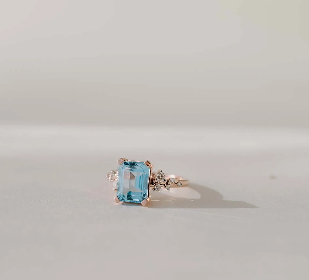 Ring with 9X7MM Emerald Cut Blue Topaz and .15 Carat TW of Diamonds 14kt Rose Gold