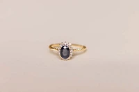 Halo Ring with .13 Carat TW of Diamonds and 7x5MM Oval Blue Sapphire 10kt Yellow Gold