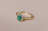 Halo Ring with .13 Carat TW of Diamonds and 7x5MM Oval Emerald 10kt Yellow Gold