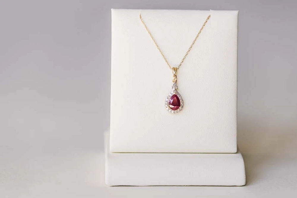 Halo Pendant with .13 Carat TW of Diamonds and 7x5MM Pear Shape Ruby 10kt Yellow Gold Chain