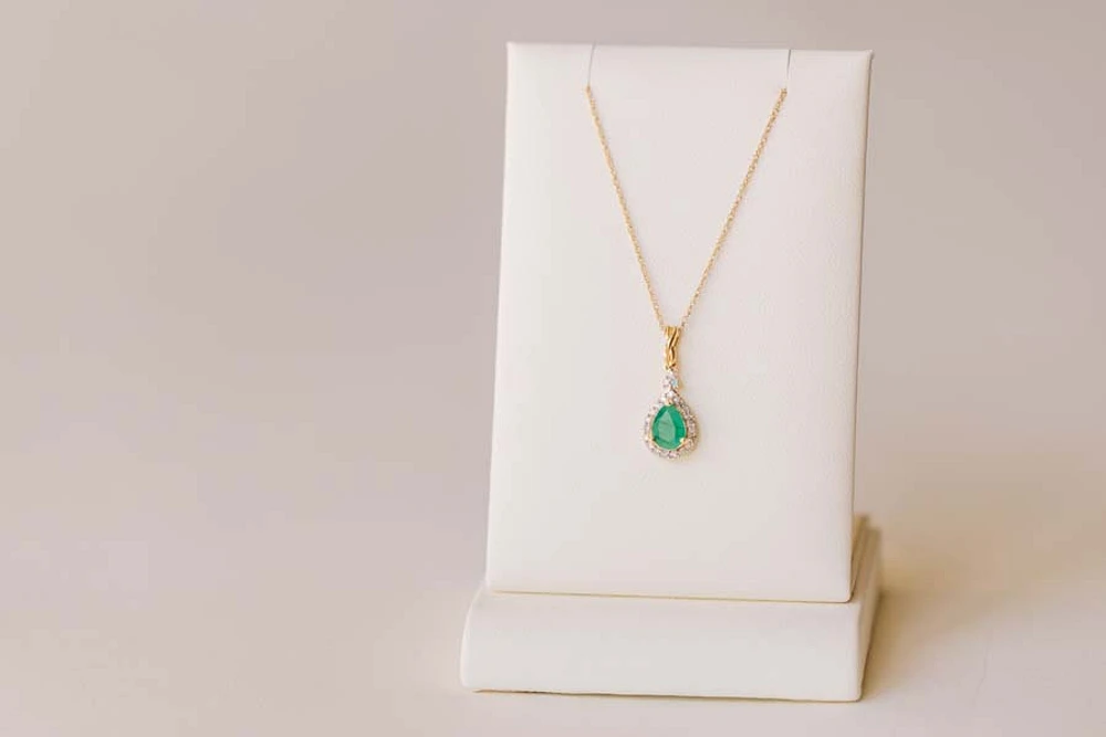 Halo Pendant with .13 Carat TW of Diamonds and 7x5MM Pear Shape Emerald 10kt Yellow Gold Chain