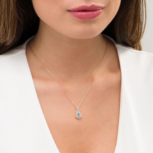 Pear-Shaped Swiss Blue Topaz and 0.15 CT. T.W. Diamond Scallop Frame Ornate Pendant in 10K Gold|Peoples Jewellers